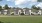 a row of white houses with a lawn in front of it